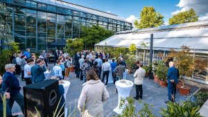 Prof. Dr. Michael Stelter am Mikrofon umrundet von Gästen im Botanischen Garten zur Abendveranstaltung des ThWIC Kick-Off